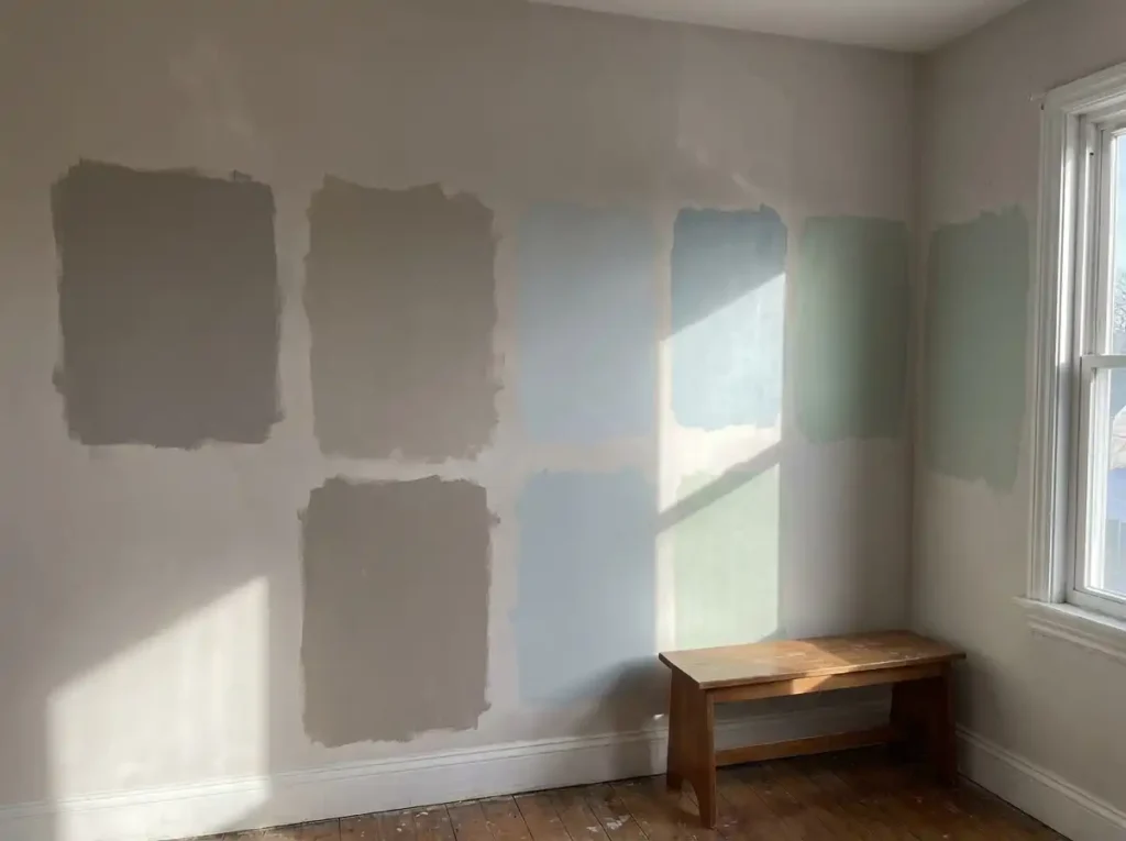 Interior south-facing wall with large painted sample swatches in neutral and cool tones