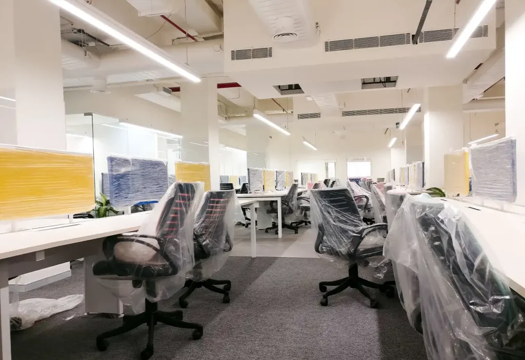 Commercial Office with chairs and desks covered in plastic for painting